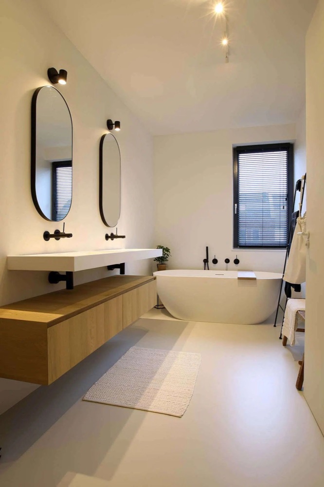 Badkamer met natuursteenlook en ronde spiegel