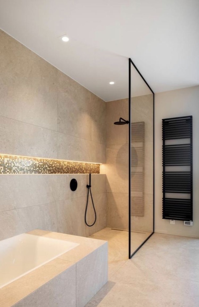 Badkamer met bad, inloopdouche en zwarte designradiator